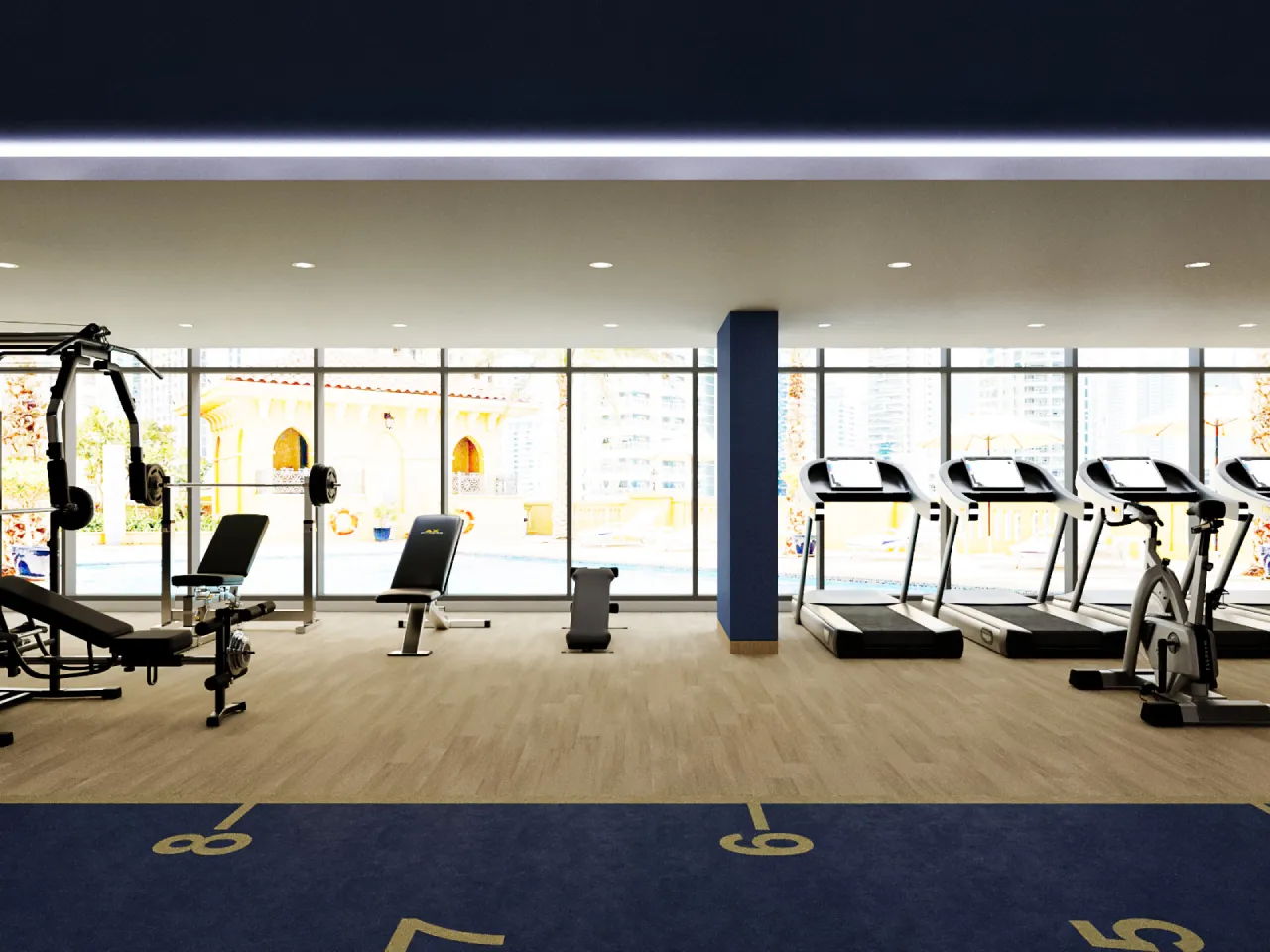 Bright shared gym with floor-to-ceiling windows, treadmills, bikes, benches, strength machines, blue columns
